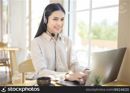 A customer service operator woman in headset using computer answering customer call in office. Customer service operator woman in headset using computer answering customer call in office