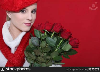 A cute blond holding a bunch of roses.