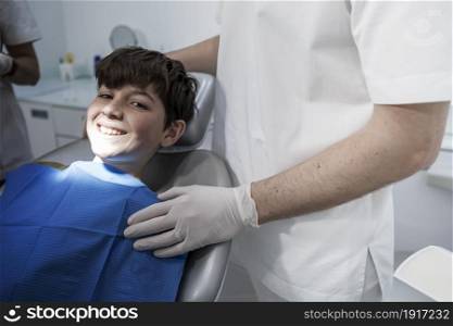 A cute boy is being examined by a professional pediatric dentist. Very happy boy after the visiting of doctor at the clinic with beautiful white smiles. Copy space.. Little boy smiling in the dental office.