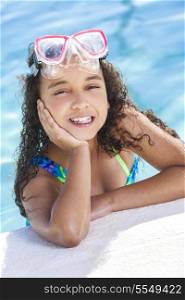 A cute happy young interracial African American girl child relaxing on the side of a swimming pool smiling &amp; wearing pink goggles