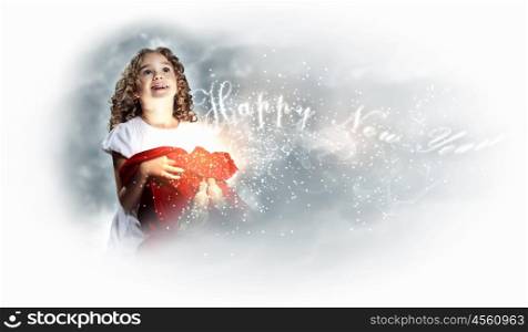 A cute young girl holding a christmas gift, dark background with christmas light bokeh