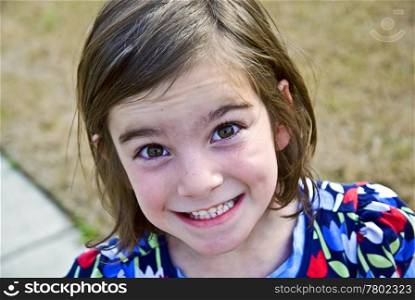 A cute young girl with a huge grin on her face.