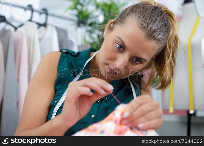 a cute young woman sewing