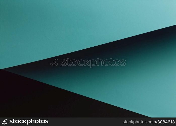 A dark blue and black flat lay background with sharp layers and shadows with copy space