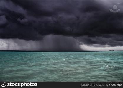 A dark storm and rain approaches a boat at Gili Lankanfushi (formerly Soneva Gili) in the Maldives