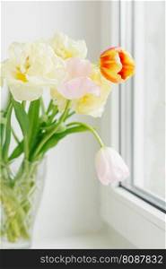 A delicate bouquet of tulips on the window. The arrival of spring, March 8, Easter, Mother’s Day. Selective Focus