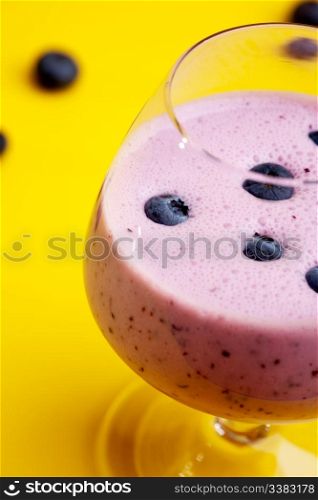 A delicious blueberry smoothie isolated on yellow