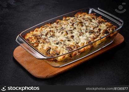 A delicious nutritious dish with meat, mushrooms, vegetables and potatoes, baked in a creamy sauce in an oven. Cooking home-cooked food. A delicious nutritious dish with meat, mushrooms, vegetables and potatoes, baked in a creamy sauce in an oven