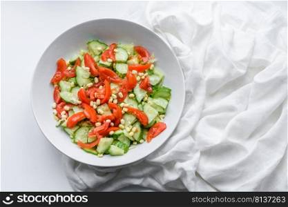 A delicious salad with beans, tomatoes and cucumbers on a white background. Making a delicious healthy breakfast. A delicious salad with beans, tomatoes and cucumbers on a white background