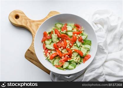 A delicious salad with beans, tomatoes and cucumbers on a white background. Making a delicious healthy breakfast. A delicious salad with beans, tomatoes and cucumbers on a white background