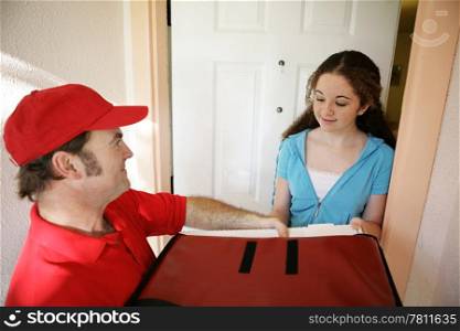 A delivery man bringing pizza to a home.