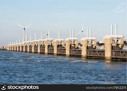 a deltaworks in holland at the Oosterschelde river to protect holland form high sea level, this is near the dutch museum neeltje jans with windmills as background