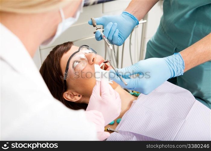A dentist giving a freezing needle to a worried patient