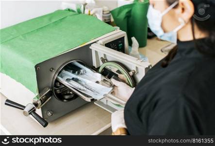 A dentist sterilizing his tools, Dentist with a dental sterilizer,  A dentist with a dental autoclave, Close up of a dentist with a steam sterilizer