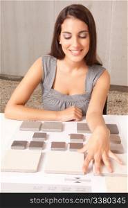 A designer looking at stone swatch tiles on table