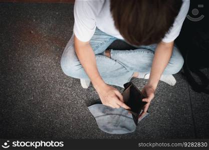 A desperate Asian opening wallet and looks at his empty wallet. Unhappy Asian people with no cash in their purses, bankrupt economic financial , Poverty in retirement, and unemployment concept.