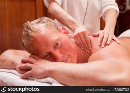 A detail of a man receiving a back and shoulder massage in an old style spa