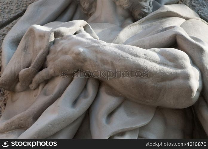 a detail of a statue showing a hand holding a towel