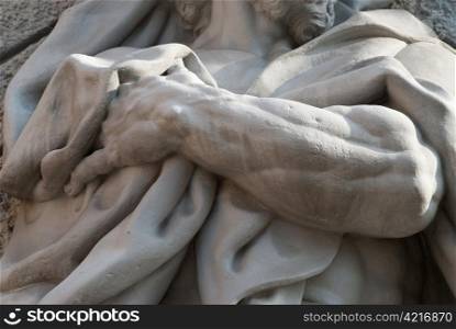 a detail of a statue showing a hand holding a towel