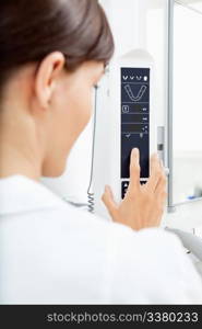 A detail of a young woman using a panormaic digital X-ray machine