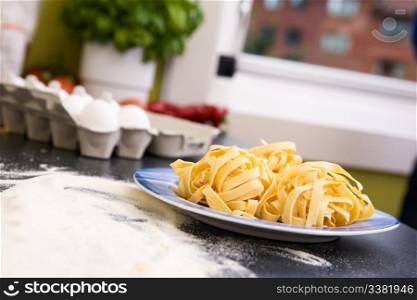 A detail of homemade fettuccine on a plate ready to be boiled