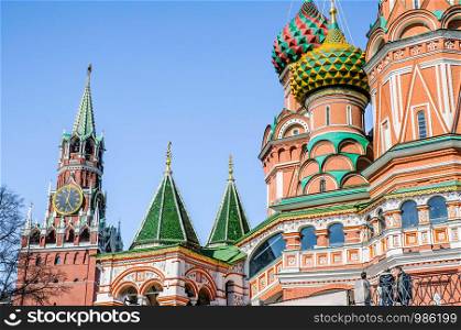 A detail of the colored steeples ot Saint Basil's Cathedral in Moscow, Russia. The clock tower of the Kremlin appears in the background