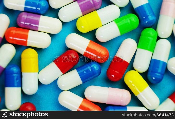 A detailed macro of pills and capsules with blue background
