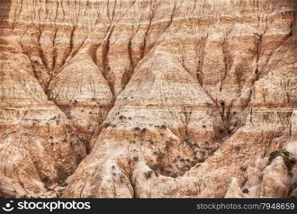 A detailed view of the erosion shaping the hills of the Badlands National Park in South Dakota.