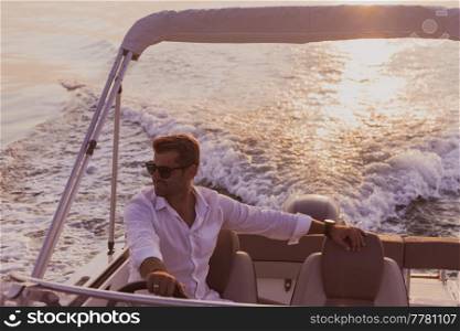 A determined senior businessman in casual clothes and sunglasses enjoys his vacation driving a luxury boat at sunset. Selective focus. High-quality photo. A determined senior businessman in casual clothes and sunglasses enjoys his vacation driving a luxury boat at sunset. Selective focus 