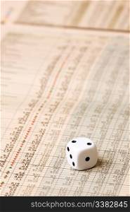 A dice sitting on a stock market chart