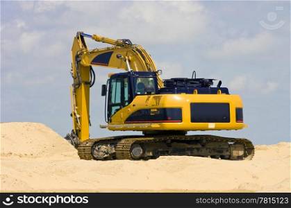 A Digger on top of a heap of sand