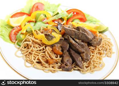 A dinner of lamb&acute;s liver stewed with onions served with salad on a bed of egg noodles.