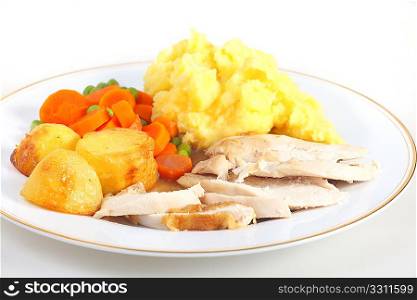 A dinner of roast chicken served with roast potatoes, mixed veg, mashed potato and gravy.