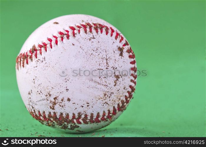 A dirty baseball over a completely green background