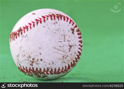 A dirty baseball over a completely green background