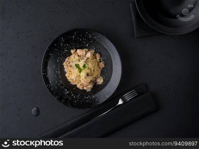 a dish of chicken on the black wooden surface, top view. a meat dish on a black surface