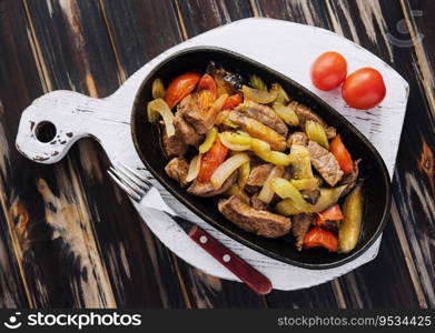 A dish of roasted meat, stewed vegetables on wood