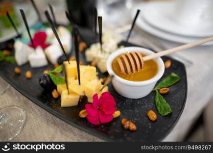 a dish of various delicious cheeses and a plate of honey.