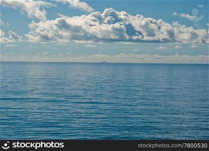 a distant ship on the flat and calm deep blue tropical ocean. missed the boat