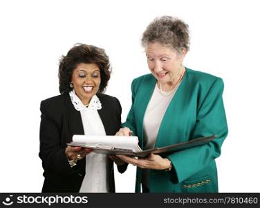 A diverse female business team excitedly looking at a report. Isolated on white.