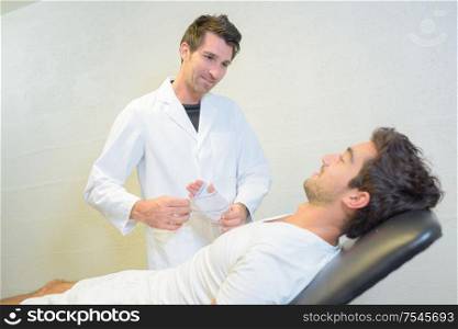 a doctor bandaging mans hand