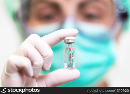 A doctor in medical gloves and mask holding an ampula with vaccine. Close up shot. Coronavirus, epidemic and medicine concept .. A doctor in medical gloves and mask holding an ampula with vaccine. Close up shot. Coronavirus, epidemic and medicine concept.