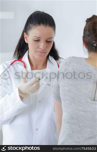 a doctor injecting patients hand