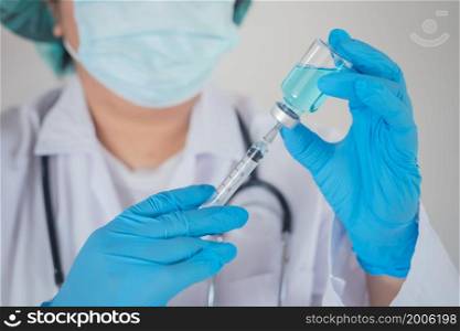 A doctor or scientist in a research laboratory holds a syringe containing a liquid vaccine. to study and analyze samples