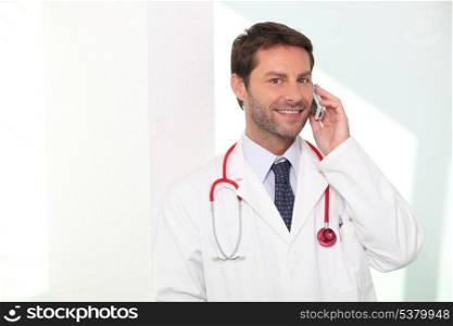 A doctor phoning and smiling.