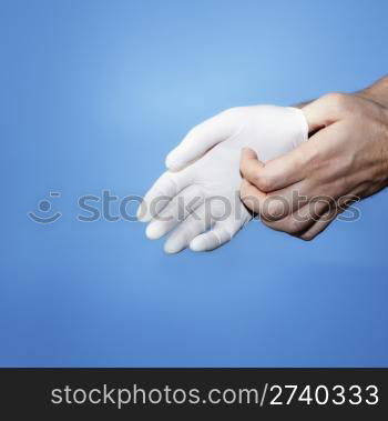 A Doctor putting on or removing a white latex rubber protective glove.