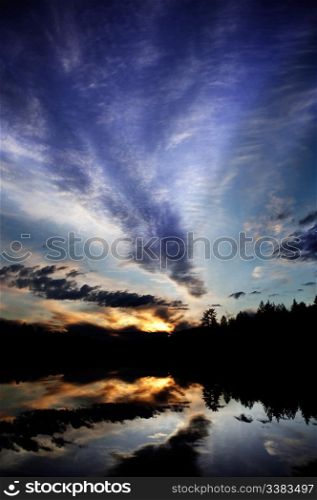 A dramatic sunset over a lake in a forest - Norway