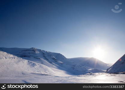 A dramatic winter landscape with snow and mountains