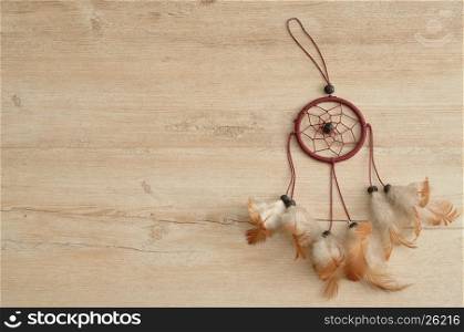 A dream catcher isolated on a wooden background