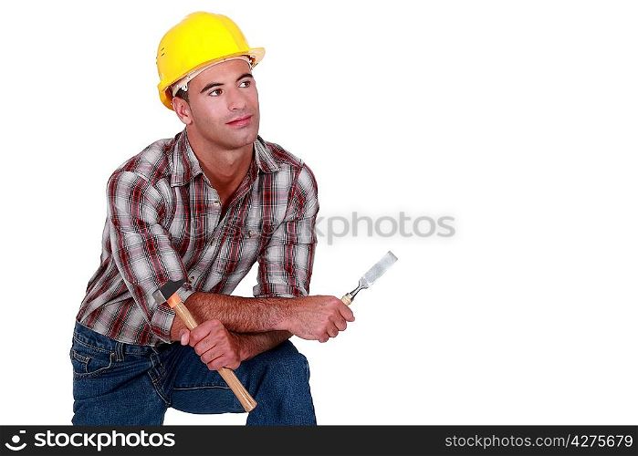 A dreamy tradesman holding a hammer and chisel